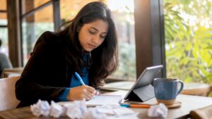 Small business owner researching keywords at desk