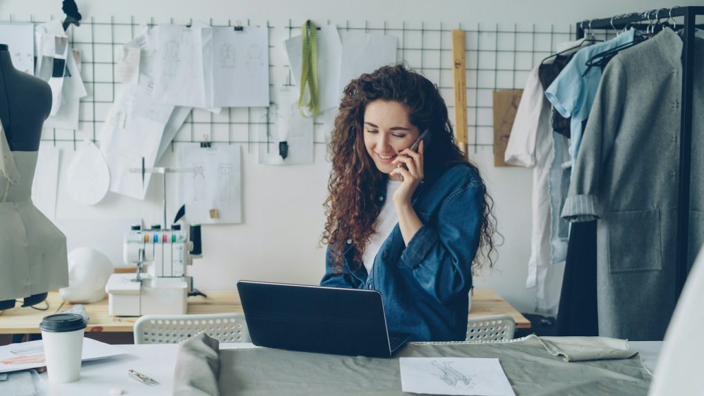 Small business owner taking a customer call while working on her laptop